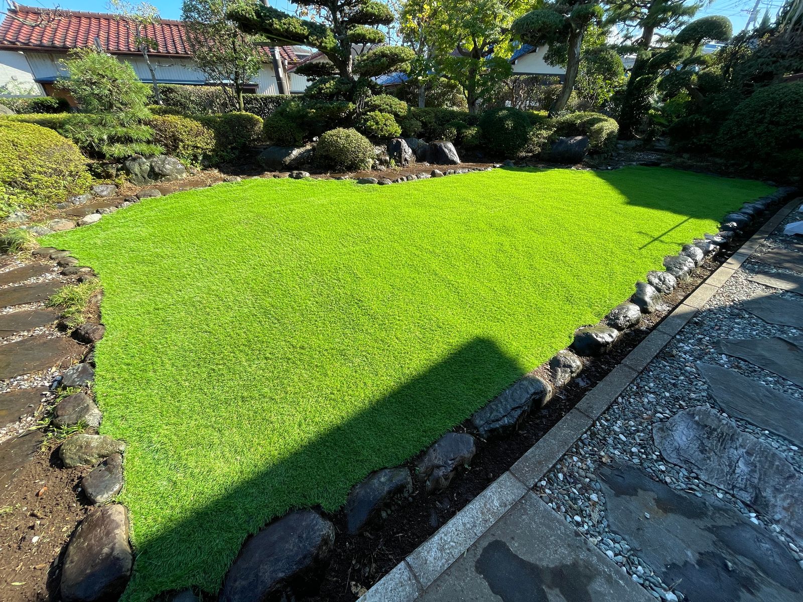 松や植え込みに囲まれた芝の和風庭園